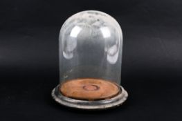 A glass display dome on stand.