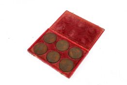 A set of six bronze medallions depicting historical figures.