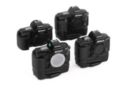 Four Nikon F90X camera bodies. Three with MB-10 Power Grips. All untested.