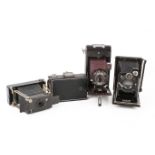 A group of four assorted vintage folding bellows film cameras.