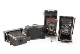 A group of four assorted vintage folding bellows film cameras.