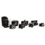 A collection of eight assorted vintage folding bellows film cameras.