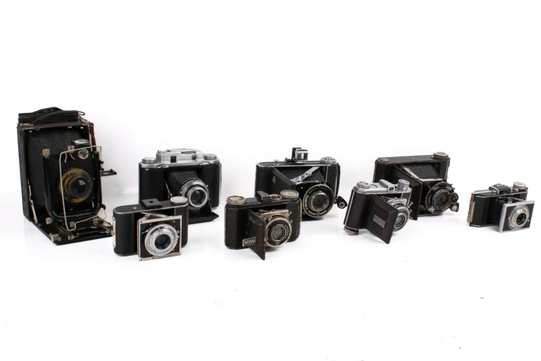 A collection of eight assorted vintage folding bellows film cameras. - Image 1 of 4