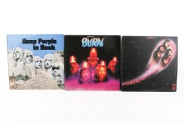 A group of three assorted Deep Purple LP vinyl records.