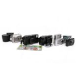 A group of six assorted compact cameras with accessories.
