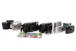 A group of six assorted compact cameras with accessories.