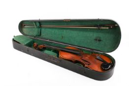 A vintage two piece backed violin and a bow in a coffin shaped case. Labelled 'Maggini'. Body 35.