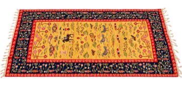 A large Kilim wool rug on a dark blue and gold ground. Having birds and insects with foliage motifs.