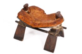 A large early 19th century Egyptian camel saddle-stool on rigid X-frame base with bound stretchers.