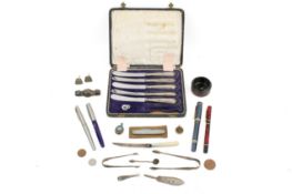 A small collection of assorted white metal, silver items and pens.