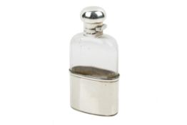 An early 20th century silver and glass hip flask.