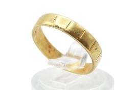 A 22ct gold band ring. With a lightly ribbed surface, width of band 3.