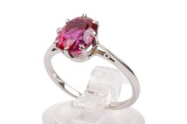 A white metal mounted red stone ring.