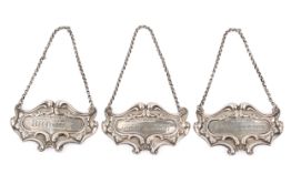 A set of three Victorian hallmarked silver spirit labels on white metal chains.