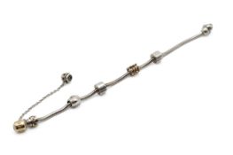A silver Pandora bracelet with stone set and two gold charms.