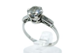 A white metal diamond ring. Set centrally with one round brilliant cut diamond of 1.