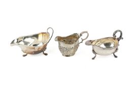 Two silver sauce boats and a cream jug.