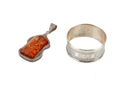 A silver and amber pendant and a silver napkin ring.
