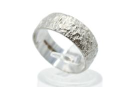 An 18ct white gold band ring. With textured surface, width 7mm, size O, weight 4.8g.