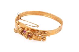 A yellow metal hinged crossover bangle.