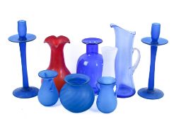 A collection of mostly blue glass items. Including a pair of large candlesticks, etc.