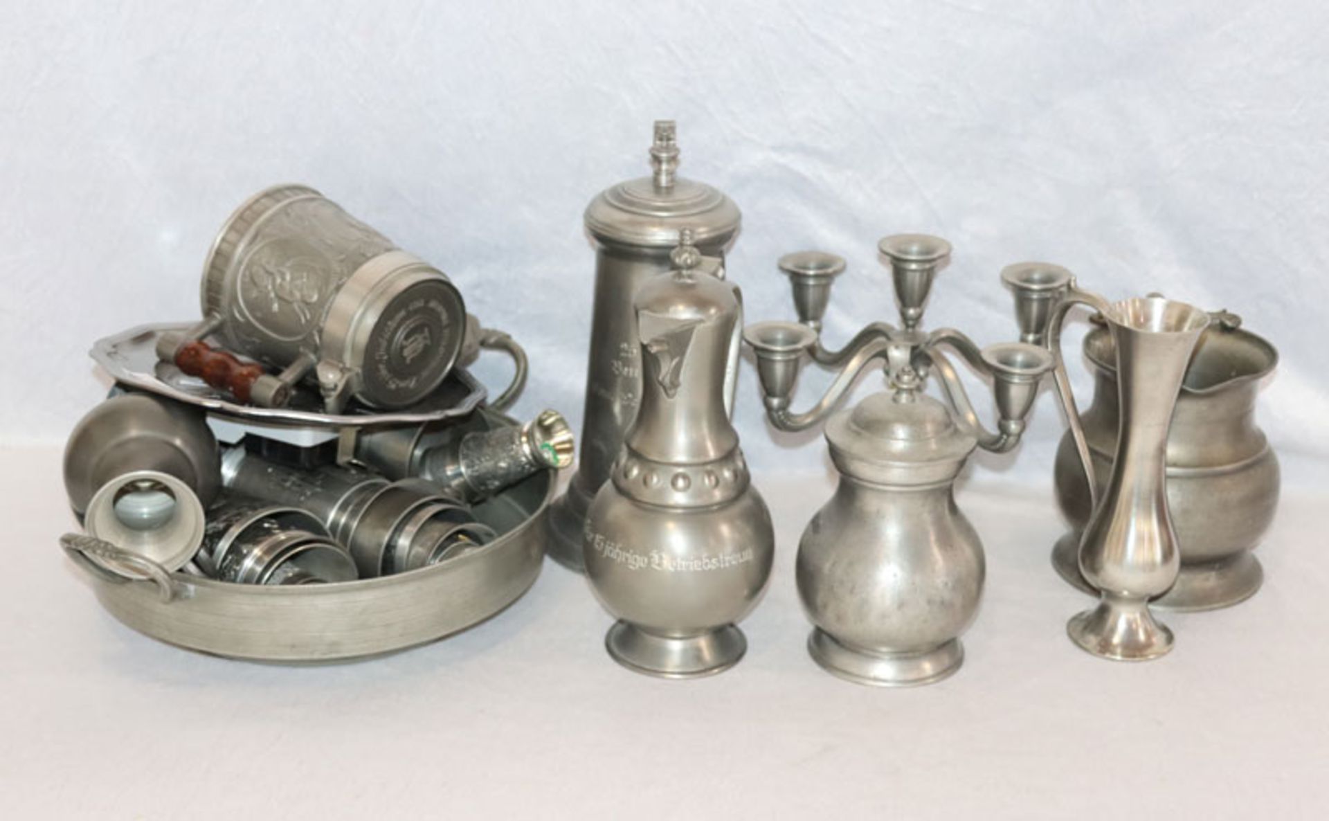 Zinn-Konvolut: Wanduhr, Schale, Bierkrug, Becher, Schnapsbecher, Kannen und Leuchter, zus. 10,5