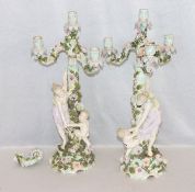 Paar Porzellan Kerzenleuchter mit plastischen Figuren und Blüten, teils bestossen und beschädigt,