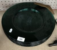 A set of seven forest green glass circular platters,