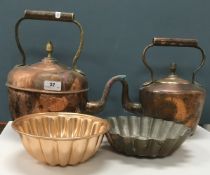 A collection of copper wares comprising two brass-handled copper kettles,