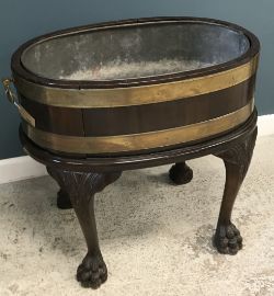 A George III mahogany wine cooler or cellarette of oval form, with tin liner,