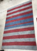 A modern blue and red striped rug, appro