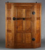 THOMPSON OF KILBURN 'MOUSEMAN' an English oak hanging corner cupboard, the single door having six