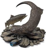 A large pottery Otter with Salmon Circling Sculpture. On a naturalistic pebble base signed N