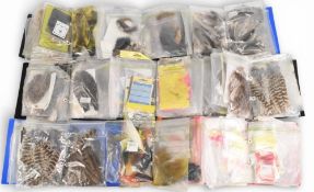 A large collection of fly tying materials in folders and bundles: wool, bucktails, fox, squirrel,