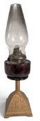 Lawn Tennis Themed Oil Lamp, cast iron base with early lawn tennis scene, red cranberry glass