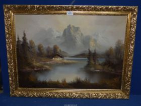 A gilt framed Oil on canvas of an Alpine lake scene with snow dusted mountains a calm body of water,