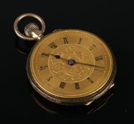 A 9ct gold fob watch with gilt dial and Roman numeral markers. Diameter 3.2cm. 17.4g. Missing glass,