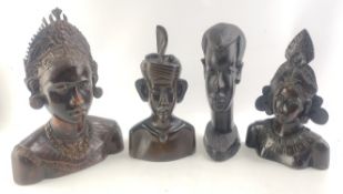A group of four carved wooden hard wood busts. Three Balinese style with one intricately carved and