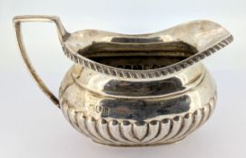 A Victorian silver milk jug with fluted body, hallmarked London 1897, weight approx 6.26.