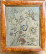 An 18th century embroidery of flowers and bird on silk, mainly stem and woven stitch, framed and
