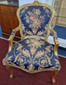 A Georgian style gilt elbow chair, with padded blue floral upholstered seat, back and arms.