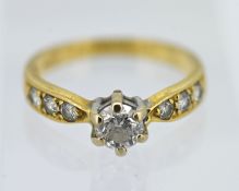 A round brilliant cut diamond single stone solitaire ring set with further diamonds to the