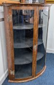 A 19th century walnut veneer corner cabinet, bow front, with brass details to hinges and lockplate,