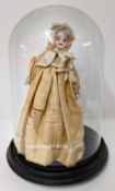 A 19th century bisque head doll in a silk dress under a dome, height approx 35cm.