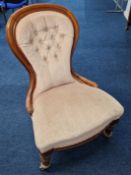 A Victorian style nursing or lady's chair, upholstered in pink velvet, on turned front legs.