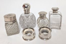 A collection of four glass perfume bottles with silver lids, hallmarks rubbed, together with two