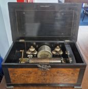 A 19th century Swiss cylinder music box, central drum flanked by six staggering bells with insect
