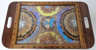 An early 20th century tray with elaborate decoration of butterfly wings under glass, including