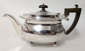 A 20th century silver teapot on bun feet, with wooden handle, hallmarked Birmingham 1938,