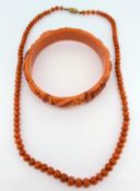 A coral carved bangle decorated with leaves and flowers together with a coral necklace.